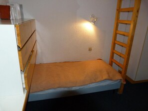 A small, single-bed room with a wooden ladder, a white dresser, and a wall-mounted light fixture. - 50m from ski slopes, 5th floor, tv, 35m², Les Arcs (Les Arcs)