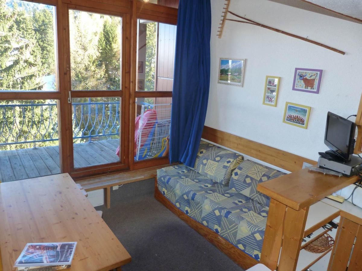 A wooden cabin with a sofa, a table, and a TV.