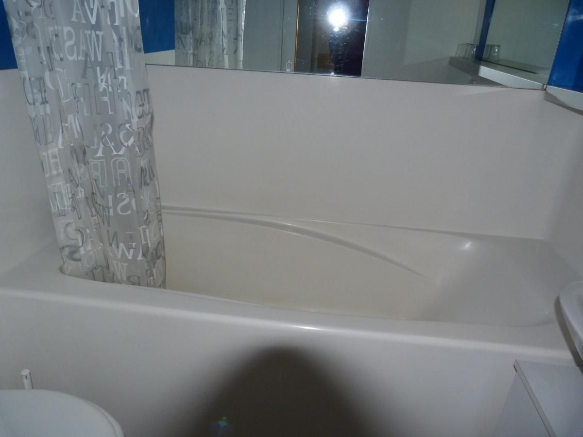 Ein Badezimmer mit Badewanne, Toilette und Duschvorhang.