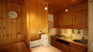Une cuisine en bois avec une horloge, une machine à café et une cuisinière.