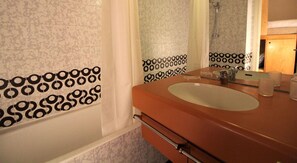 Ein Badezimmer mit einer Badewanne, einem Waschbecken und einem Spiegel.