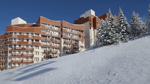 A multi-story hotel with balconies, situated on a snow-covered slope. - 3rd floor, view ski slopes/mountain/ski slopes, balcony, tv, ski locker, 25m², Les Menuires (Les Menuires)