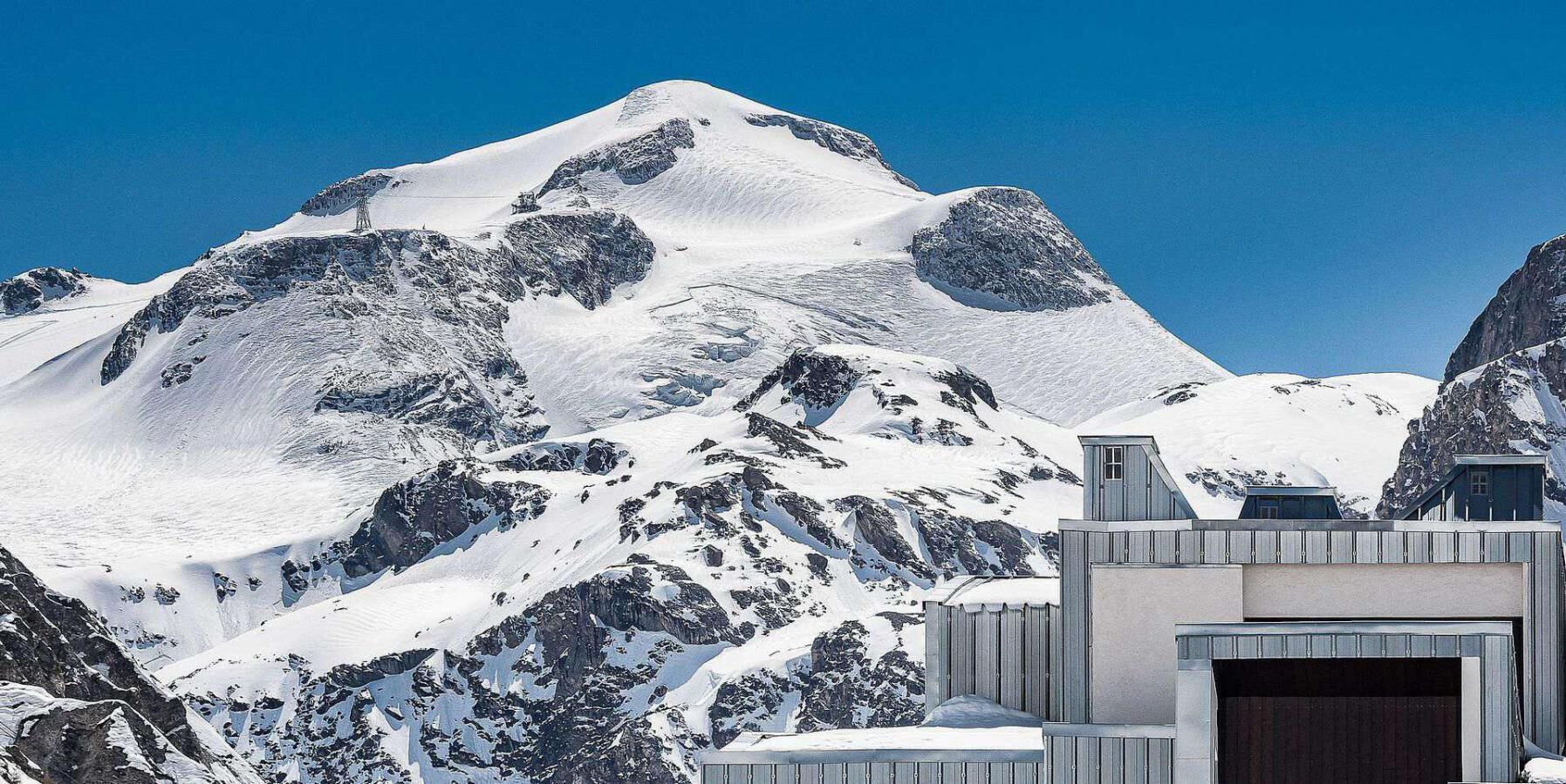 Ein schneegebdeckter Berg mit einem modernen Gebäude und einer großen Garage.