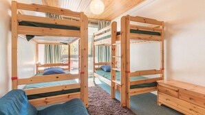 A room with bunk beds, a wooden dresser, and a view of the outdoors. - 350m from ski slopes, 1st floor, terrace, parking, tv, 56m², Serre Chevalier (SERRE CHEVALIER)