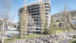A multi-story building with balconies, surrounded by trees and a stone wall. - 350m from ski slopes, 1st floor, terrace, parking, tv, 56m², Serre Chevalier (SERRE CHEVALIER)