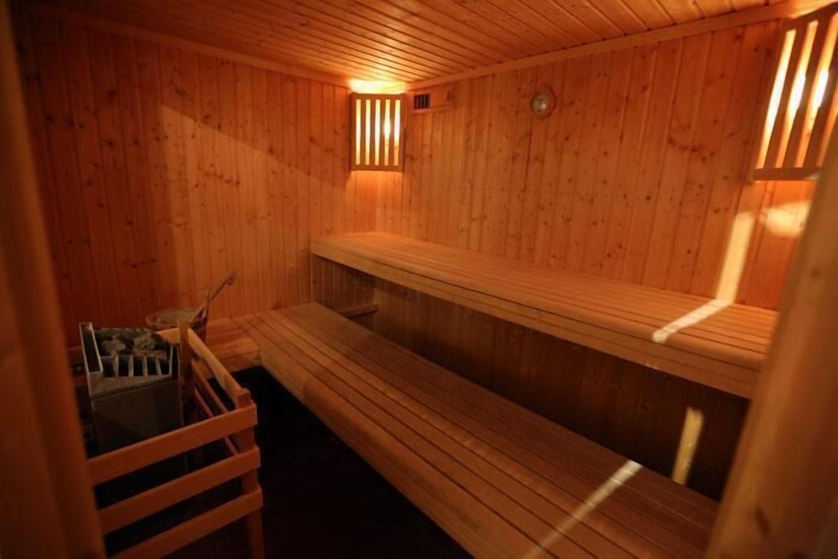 Una sauna in legno con panche e una seduta a banco.