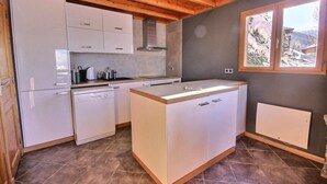 A compact kitchen with white cabinetry, a dishwasher, and a window with a view of trees and mountains. - Chalet, 350m from ski slopes, balcony, fireplace or stove, tv, 100m², Peisey-Vallandry (Landry)