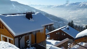 A wooden cabin with a snow-covered roof, set against a mountainous backdrop. - Chalet, 350m from ski slopes, balcony, fireplace or stove, tv, 100m², Peisey-Vallandry (Landry)