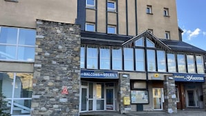 A building with a stone facade, large windows, and signage for 'Balcons du Soleil 1' and 'Maison de Peyragudes'. - Floor -1, jacuzzi, hammam, terrace, balcony, tv, ski locker, 28m², Peyragudes (Germ)