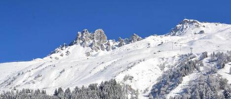 A snowy mountain landscape with a clear blue sky.