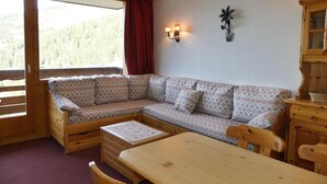 Ein gemütliches Blockhaus-Interieur mit einer Holzbank, einem Esstisch und einem Schrank.