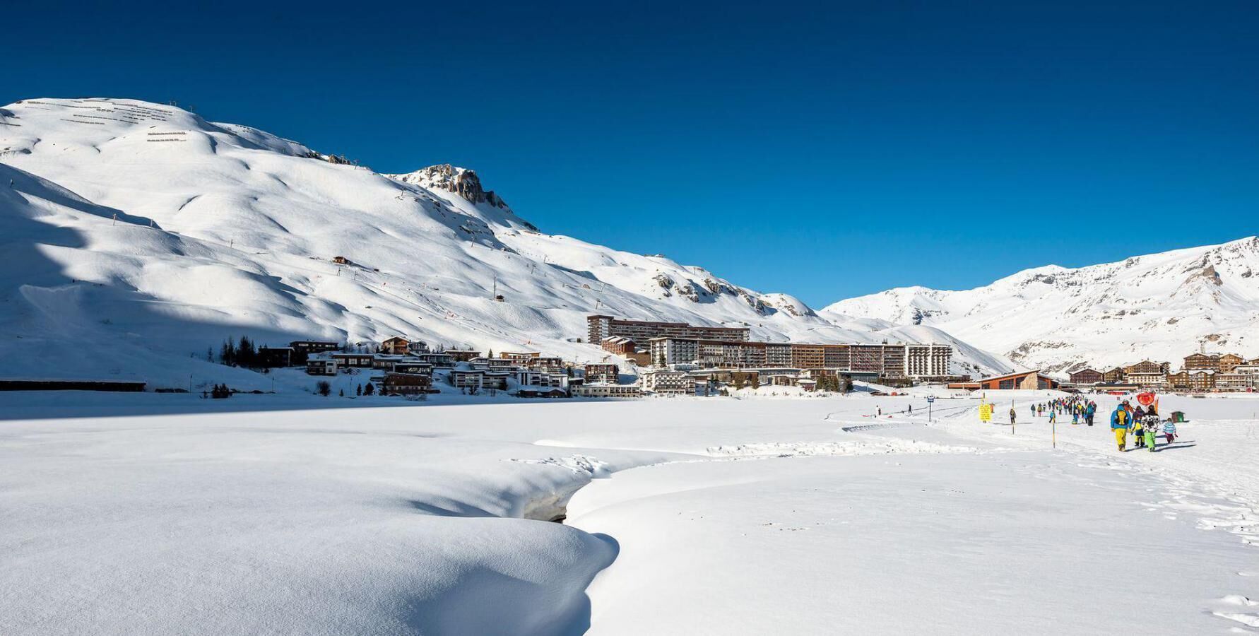 A snow-covered mountain with a resort building in the background.