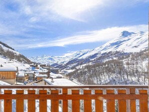 A snow-covered mountain village with wooden buildings and a wooden fence in the foreground. - Chalet, wifi, terrace, fireplace or stove, parking, tv, ski locker, 190m², Les Menuires (Les Menuires)
