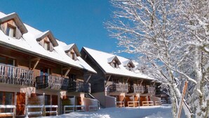 A snow-covered building with multiple balconies and a clear sky.
