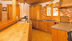 Una cocina con armarios de madera, piso de baldosas y salpicadero de ladrillo.