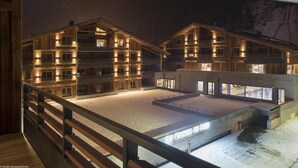 Une maquette d’un hôtel à plusieurs étages, doté de balcons et d’une enseigne indiquant « Le Cristal de Jade Suites & Apartments ».