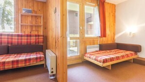 Une chambre avec deux lits, un radiateur et une fenêtre avec des rideaux.