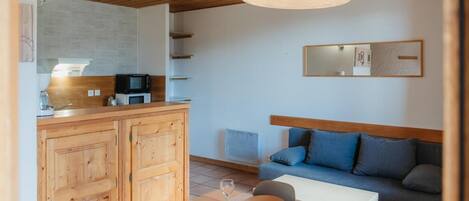 A compact living space with a kitchenette, a dining area, and a sofa.