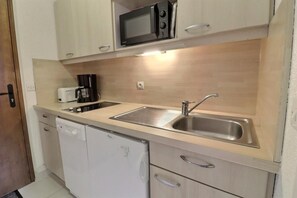 A compact kitchen with a microwave, coffee maker, and a dishwasher. - 10m from ski slopes, 1st floor, balcony, 27m², Méribel-Mottaret (Méribel - Les Allues)