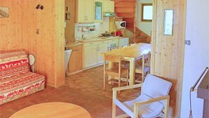 A wooden interior with a dining area, a kitchen, and a living room.