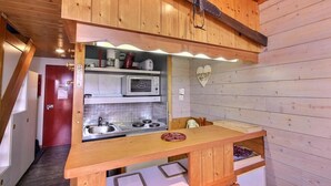 A compact kitchen with a microwave, sink, and wooden counter. - 50m from ski slopes, Ground floor, balcony, tv, 40m², Peisey-Vallandry (Landry)