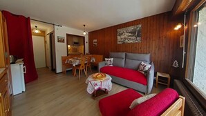 A cozy room with a sofa, a dining table, and a small kitchen area. - 3rd floor, balcony, tv, 26m², Le Grand Bornand (Le Grand-Bornand)