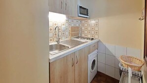 A compact kitchen with a sink, microwave, and washing machine. - 3rd floor, balcony, tv, 26m², Le Grand Bornand (Le Grand-Bornand)