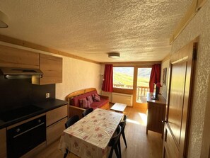 A compact kitchen with a dining table, a sofa, and a view of the outdoors. - 10m from ski slopes, floor -2, balcony, tv, ski locker, 35m², Les Menuires (Les Menuires)