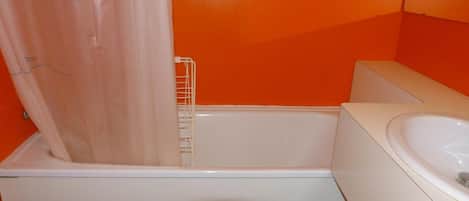 A bathroom with a bathtub, a toilet, and a sink.