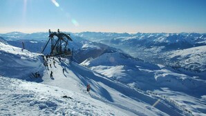Een skilift op een besneeuwde berg met heldere lucht.