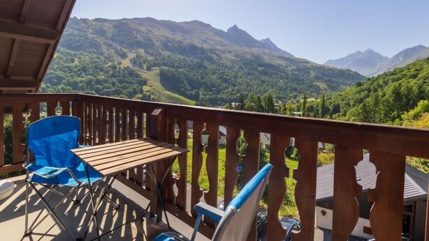 A wooden deck with a table and chairs, overlooking a mountainous landscape. - 4th floor, swimming pool, balcony, tv, ski locker, 37m², Valloire (Valloire)