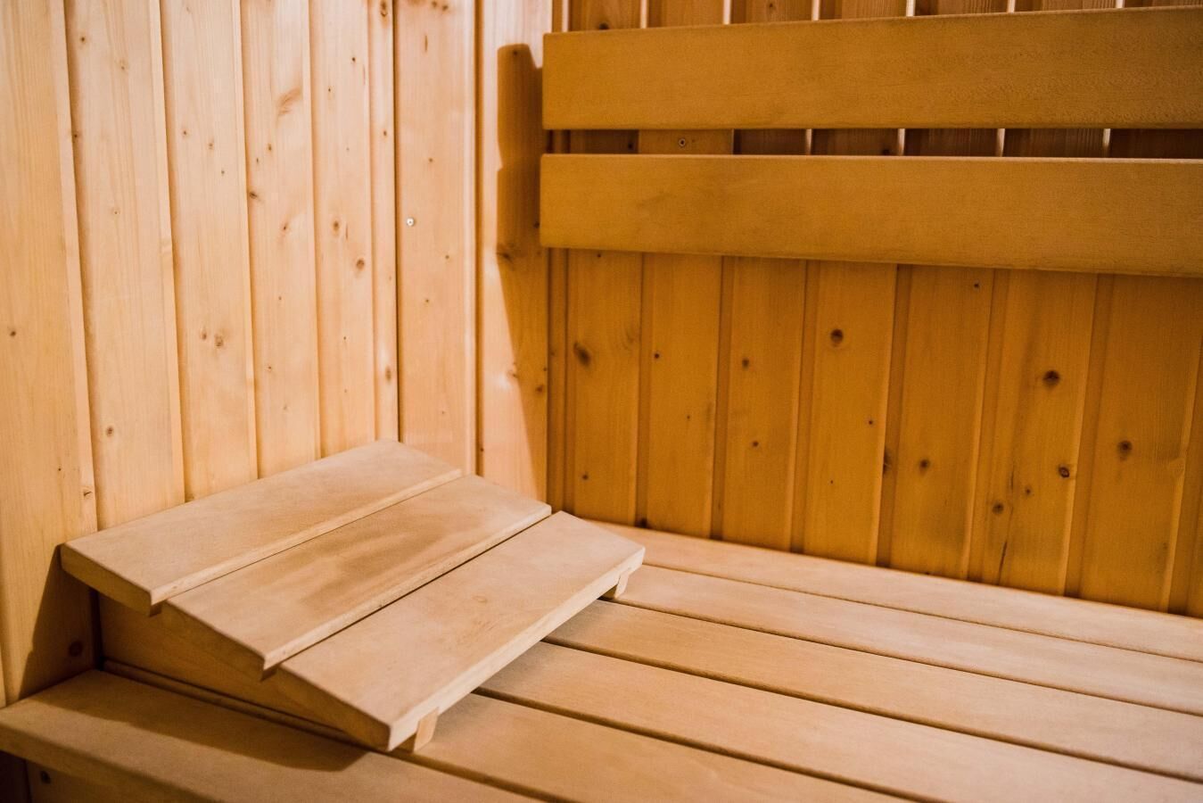 Un banc de sauna en bois avec un dossier à lattes.