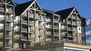 A multi-story hotel with balconies and a sign indicating it is a residence of tourists.