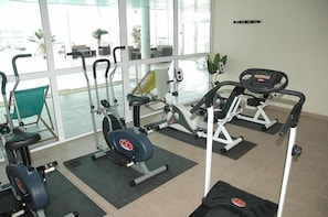 A gym with various exercise equipment, including treadmills, stationary bikes, and weight machines.