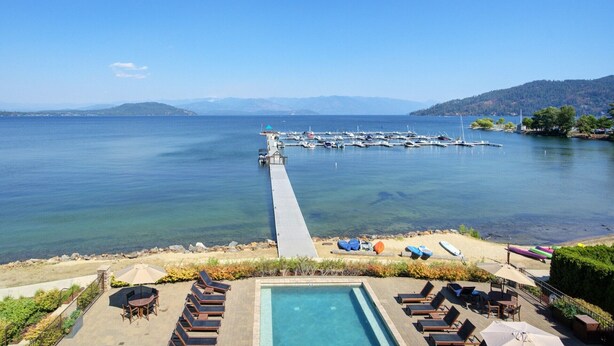 A pool area with lounge chairs and a view of a marina with boats. - Master Suite w/Lake Views - Seasons at Sandpoint (Sandpoint)