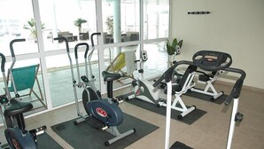 Uma academia com diversos equipamentos de exercício, incluindo esteiras, bicicletas ergométricas e aparelhos de musculação.