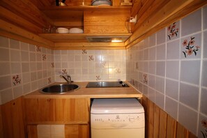 A compact kitchen with wooden cabinets, a sink, and a dishwasher.