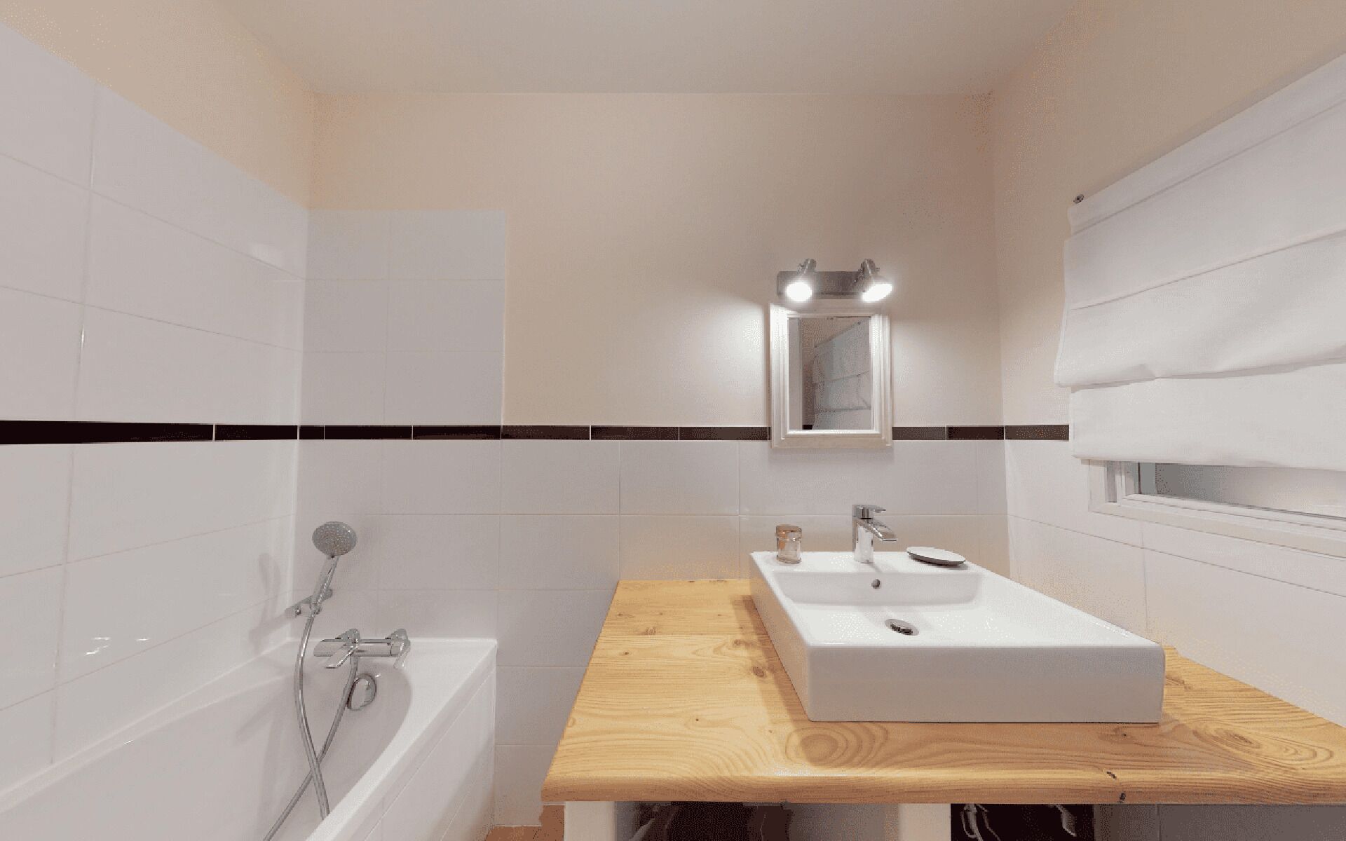 A modern bathroom with a bathtub, a wooden vanity with a sink, and a mirror.