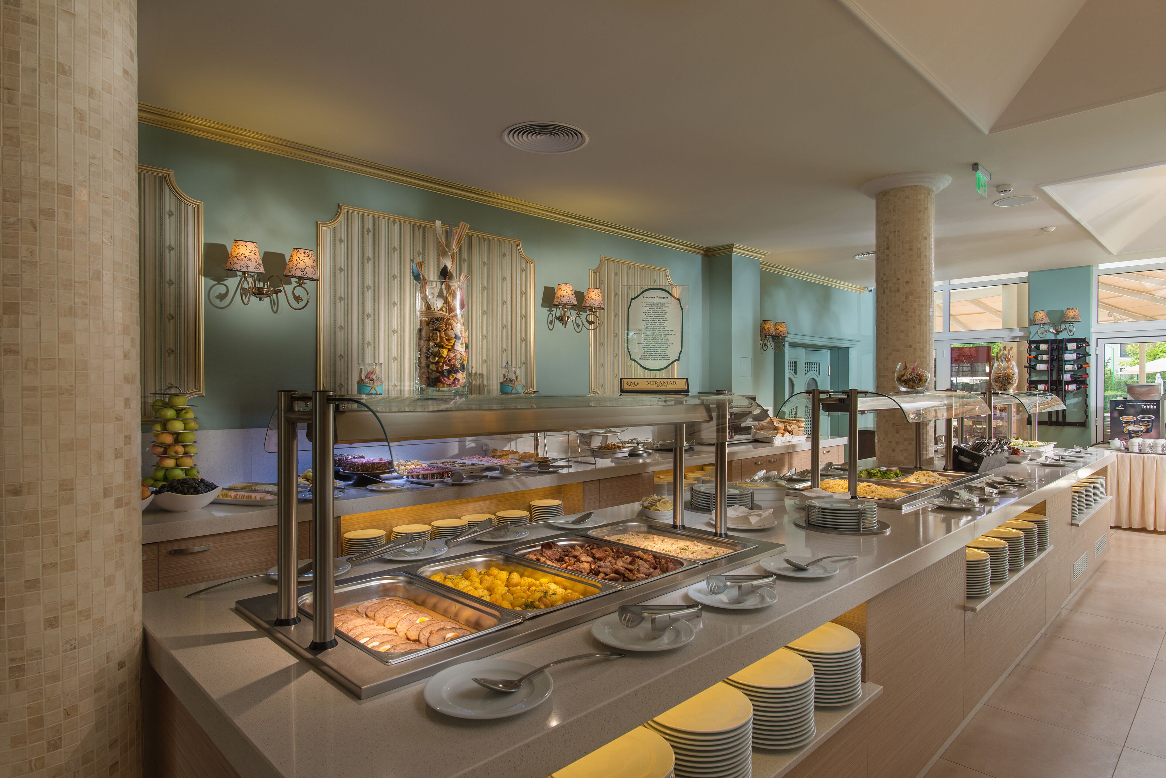 A buffet with various food options, a mirror, and wall-mounted lights.