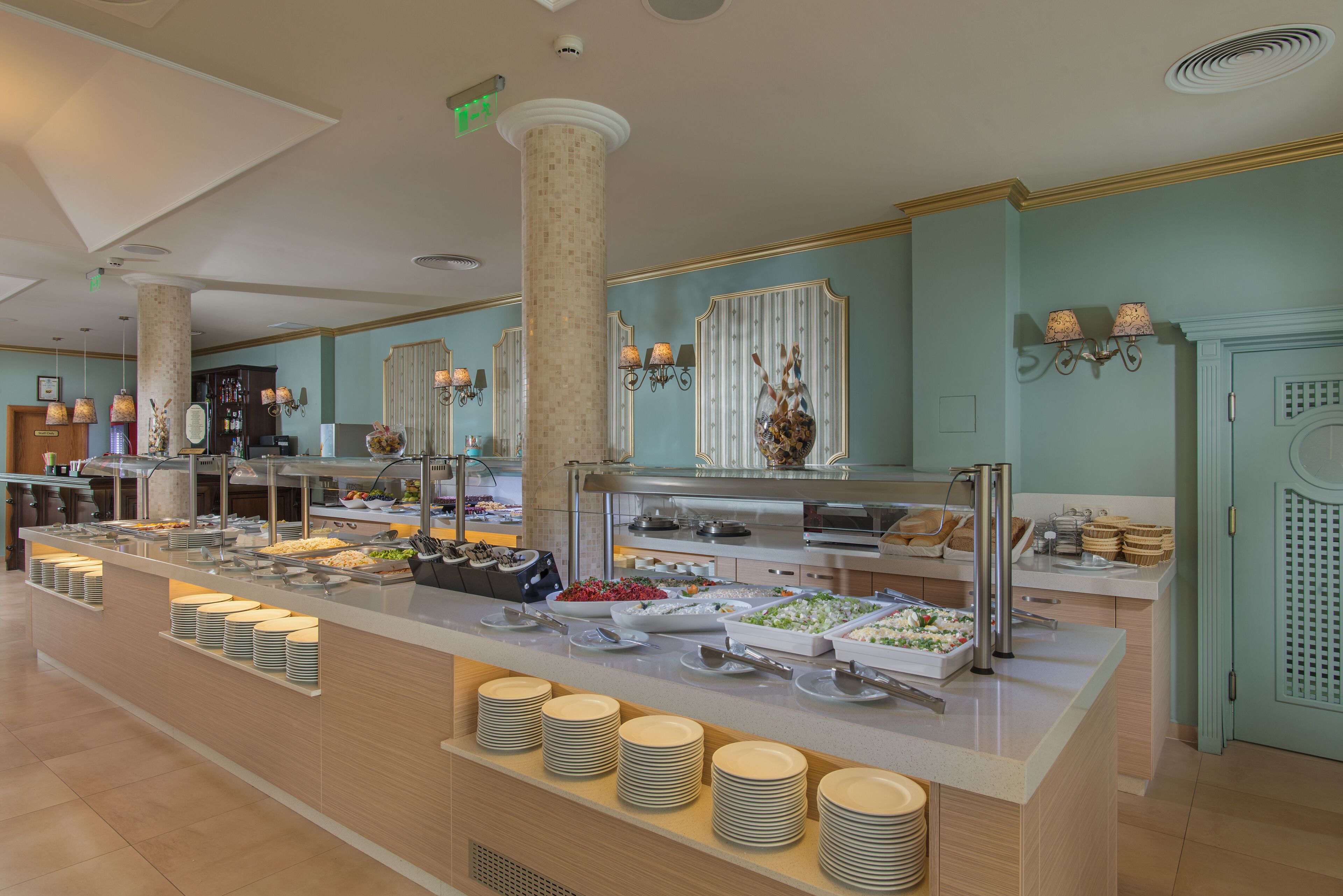 Een buffetgedeelte met verschillende food stations, een centraal bedieningspunt en diverse gerechten gepresenteerd op schalen.