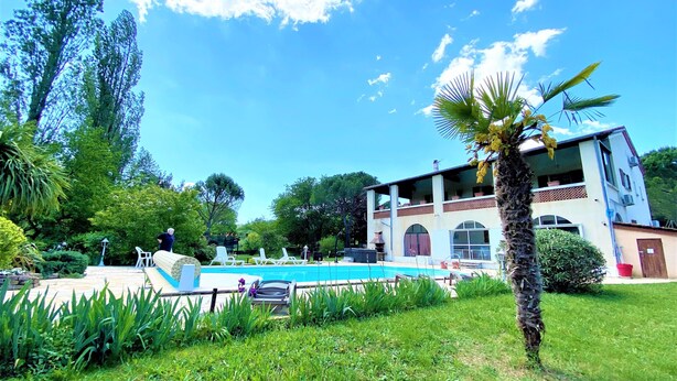 A two-story building with a pool and outdoor seating. - Vacation rental for 2–4 people, 1 bedroom, 1 shower room, heated outdoor pool, garden, trampoline (Ardèche)