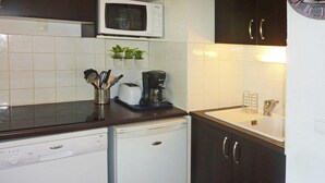 Een functionele keuken met een vaatwasser, een koffiezetapparaat en een magnetron.
