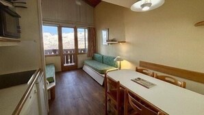 Eine kompakte Küche mit Essbereich, einem Fenster mit Aussicht und einer Deckenleuchte.