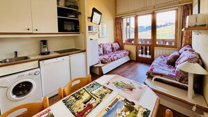 Ein gemütliches Zimmer mit einer Küche, einer Essecke und einem Sofa mit Blick.