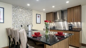 A modern kitchen with a central island, wooden cabinets, and a tiled backsplash. - Walk to Thunderhead Lift! Hot Tub/ Pool! Quiet Building! (Steamboat Springs)