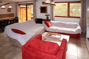 A cozy room with two beds, a dining table, and a TV.