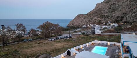 Ein Resort mit Pool, Sitzgelegenheiten im Freien und Meerblick.