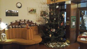 Un salon chaleureux avec un sapin de Noël, un canapé et une table basse.