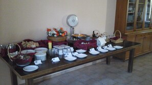 Une table de buffet avec divers plats, assiettes et un verre à vin.
