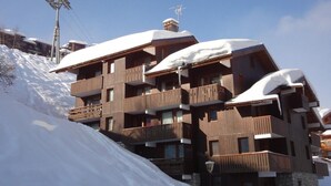 A multi-story wooden building with balconies, surrounded by snow. - 250m from ski slopes, 4th floor, balcony, 38m², Méribel-Mottaret (Méribel - Les Allues)